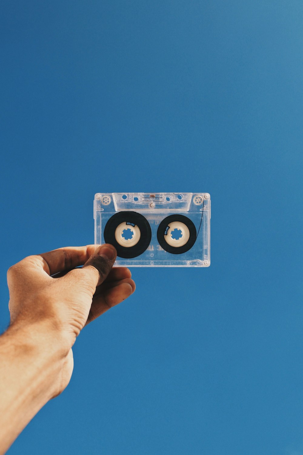 person holding white and black cassette tape
