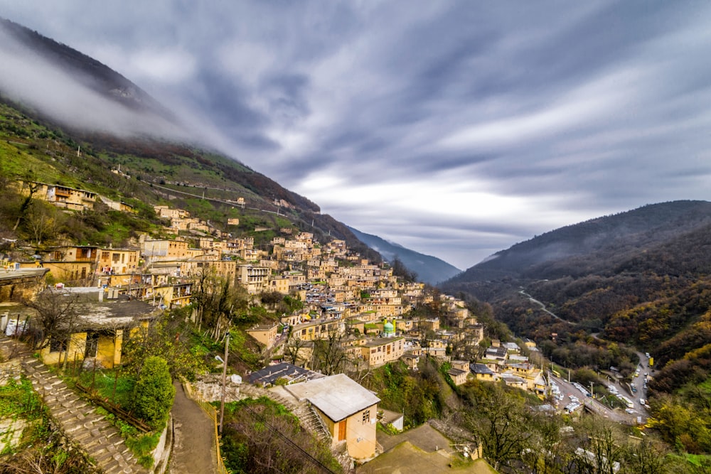 houses on mountain under cloudy sky during daytime