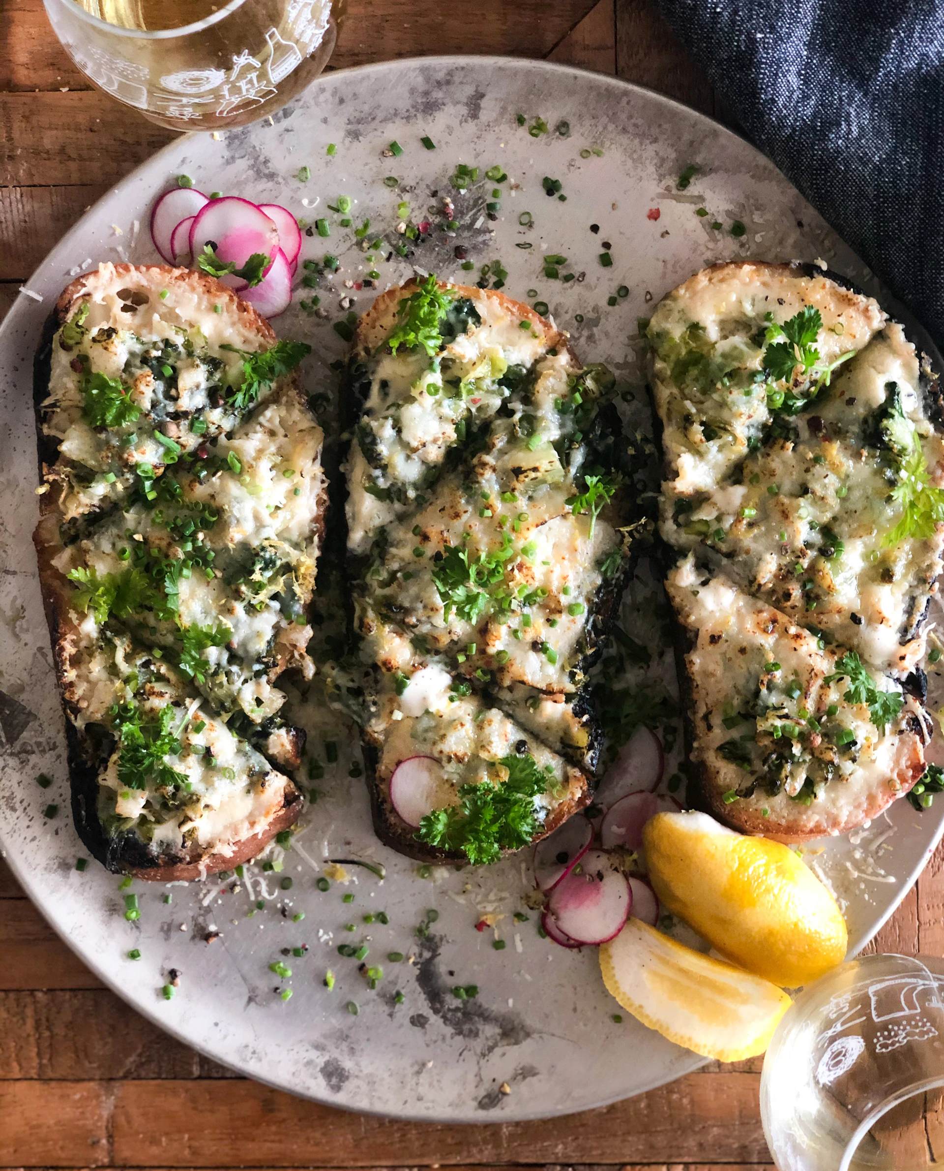 Artfully arranged toasts with creamy goat cheese, piquillos peppers, and a drizzle of olive oil on thick artisanal bread.