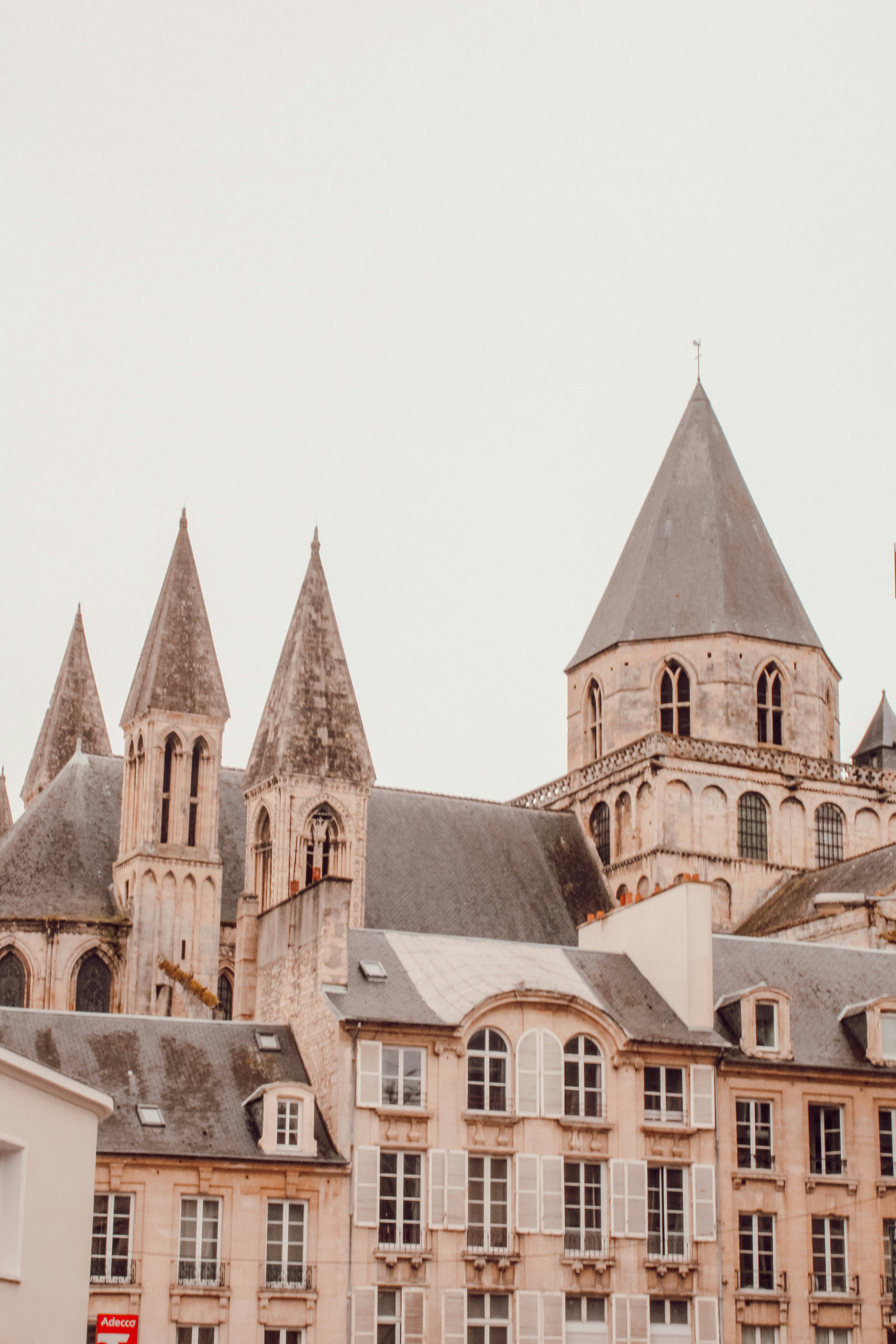 Edificio de hormigón marrón bajo el cielo blanco durante el día