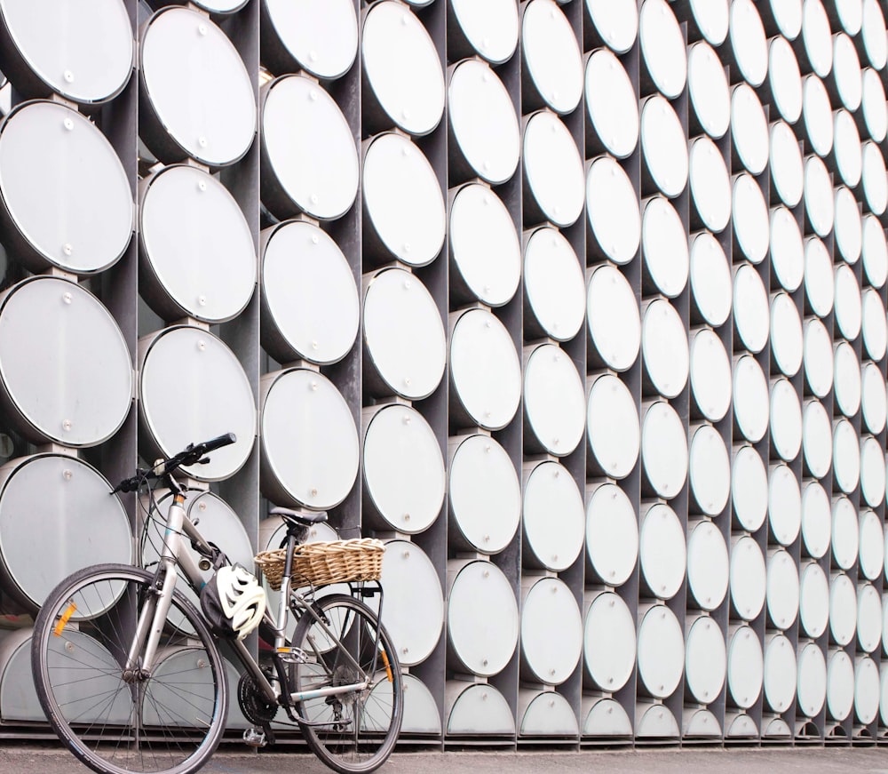 a bicycle parked next to a wall with circles on it