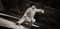 man in white robe sitting on wooden dock