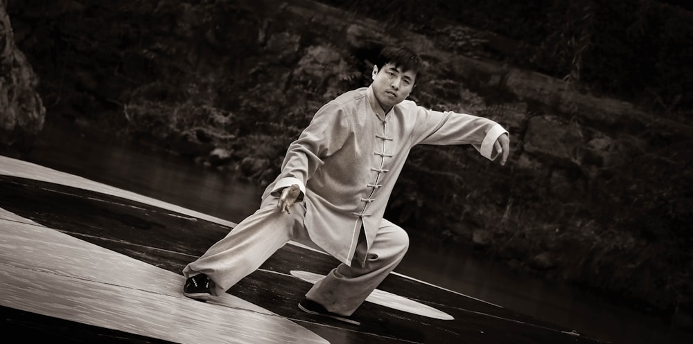 man in white robe sitting on wooden dock