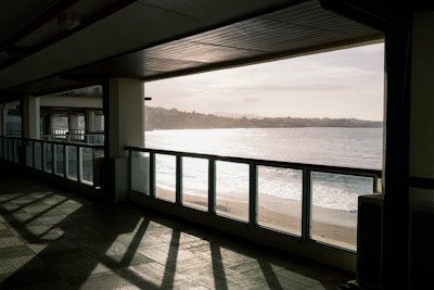 A serene beachside hotel lobby with white sandy background and sunlight streaming through large windows.