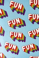 A pattern of the word 'FUN' repeated multiple times on a light blue background. Each 'FUN' is written in bold white letters with a multi-colored, layered shadow effect.