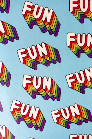 A pattern of the word 'FUN' repeated multiple times on a light blue background. Each 'FUN' is written in bold white letters with a multi-colored, layered shadow effect.