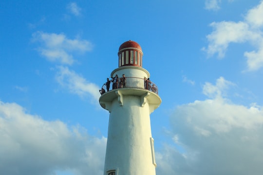 white and red concrete lighthouse under blue sky during daytime in Naidi Hills Philippines