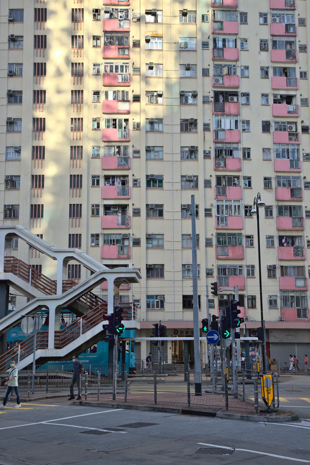 people walking on street near white and pink concrete building during daytime