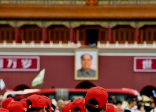 people in red and white uniform standing in front of red and white building during daytime