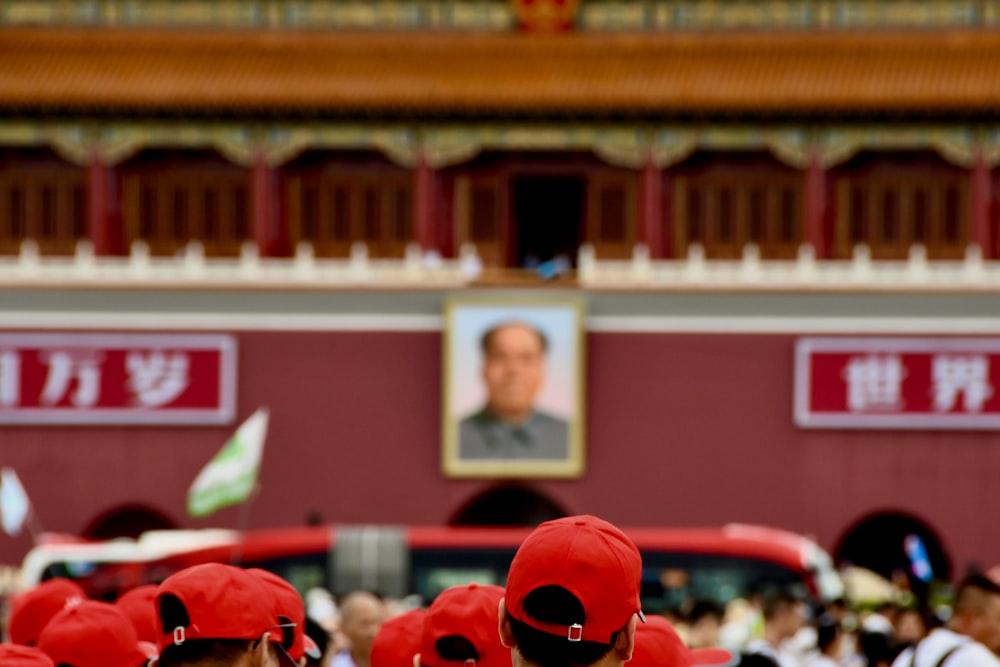 people in red and white uniform standing in front of red and white building during daytime