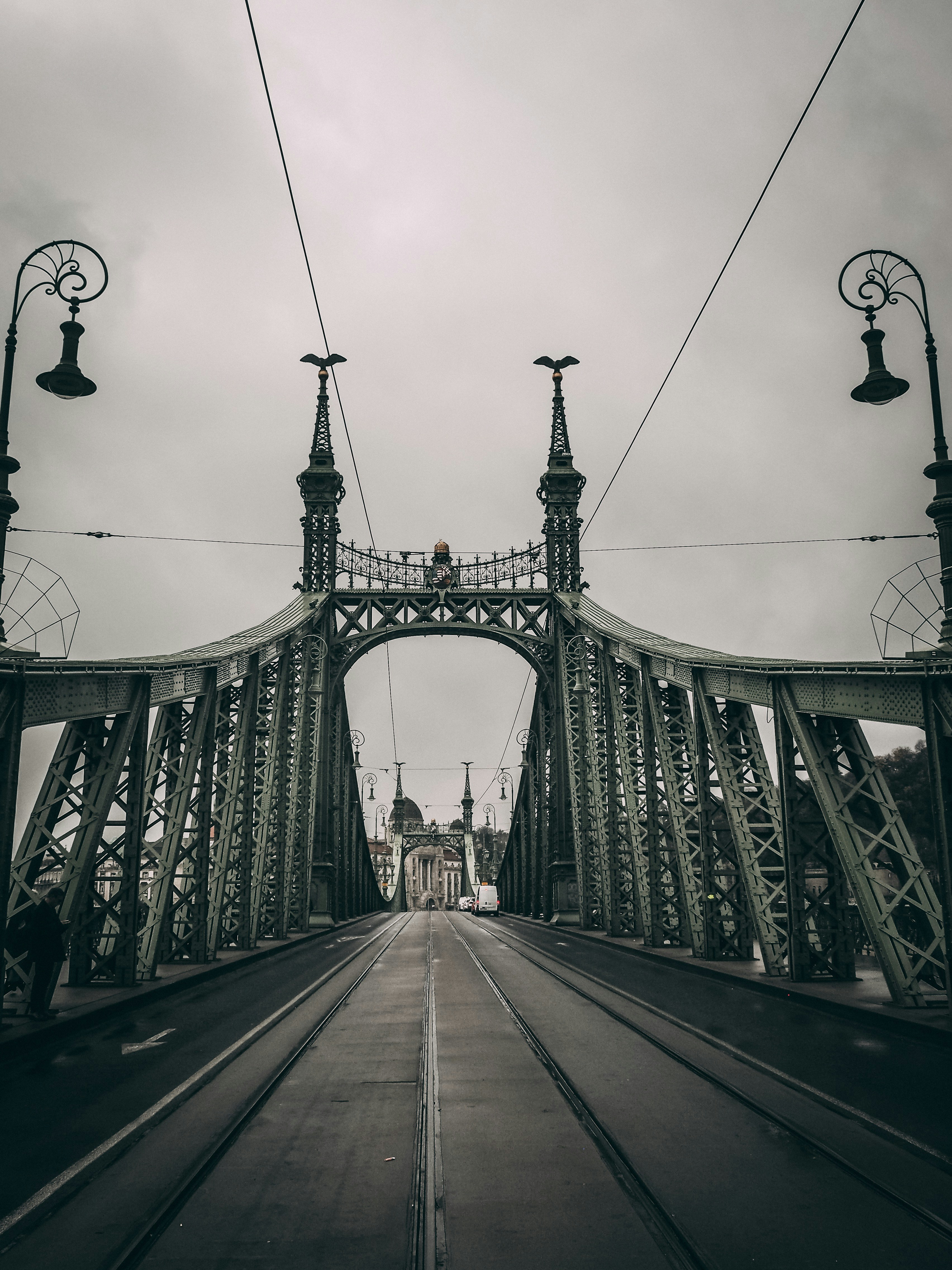 Menschen, die tagsüber unter bewölktem Himmel auf der Brücke spazieren gehen