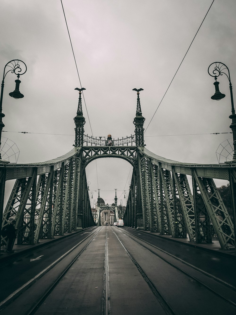 people walking on bridge under cloudy sky during daytime