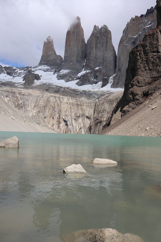 brown rock formation on body of water during daytime in Torres del Paine Chile