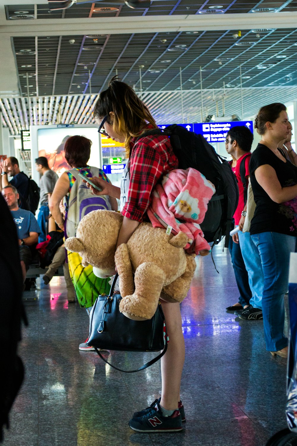 woman in black shirt holding brown bear plush toy