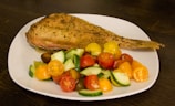 Grilled fresh fish served on a rustic wooden platter with Amazonian herbs.