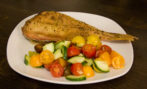Spicy Virgin seasoning sprinkled over grilled fish on a rustic wooden table.