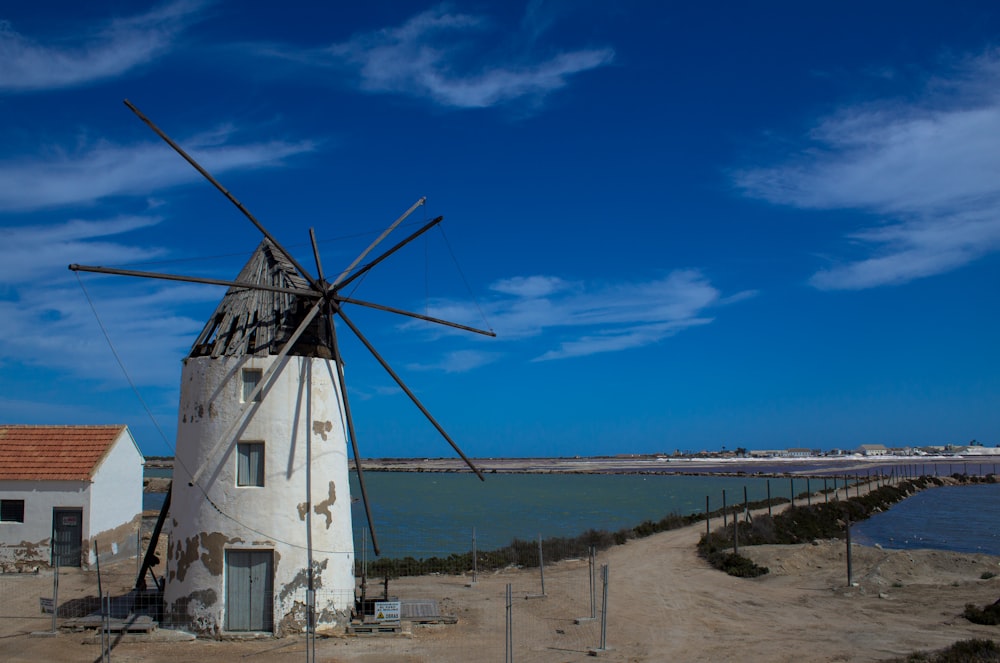 white and brown windmill near sea under blue sky during daytime