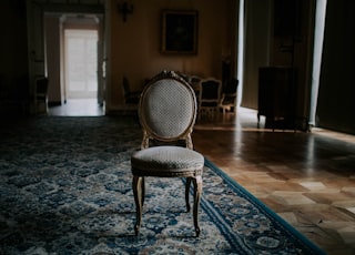 brown wooden chair on blue and white floral area rug