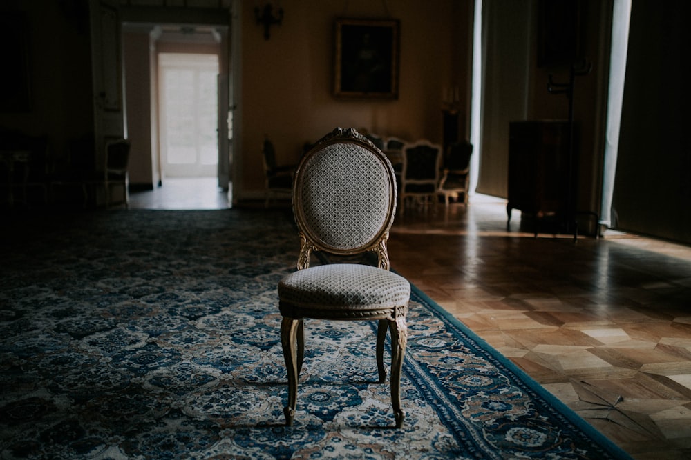 Chaise en bois marron sur tapis floral bleu et blanc