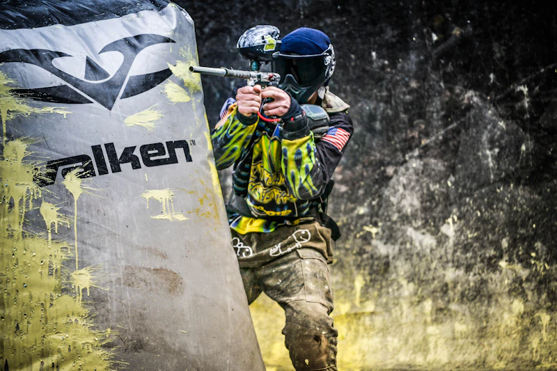 Katonai mintás öltözékben álló paintballos játékos
