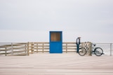 man in black shirt and blue denim jeans riding bicycle on white sand during daytime