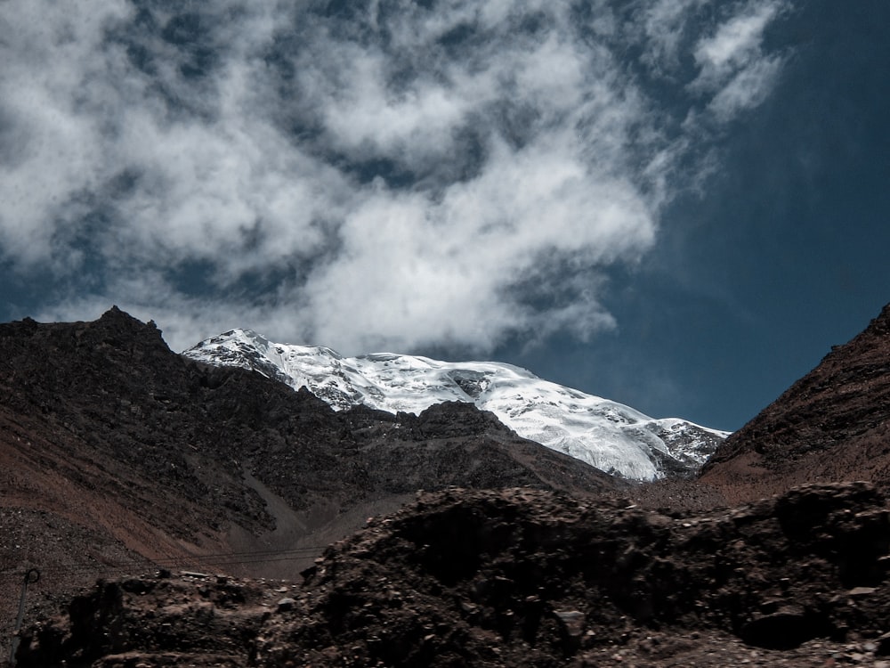 brown and white mountains under white clouds and blue sky during daytime