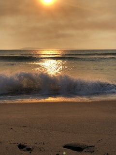 Sunset view of the beach with soft waves and golden light