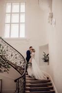 bride and groom standing on stairs
