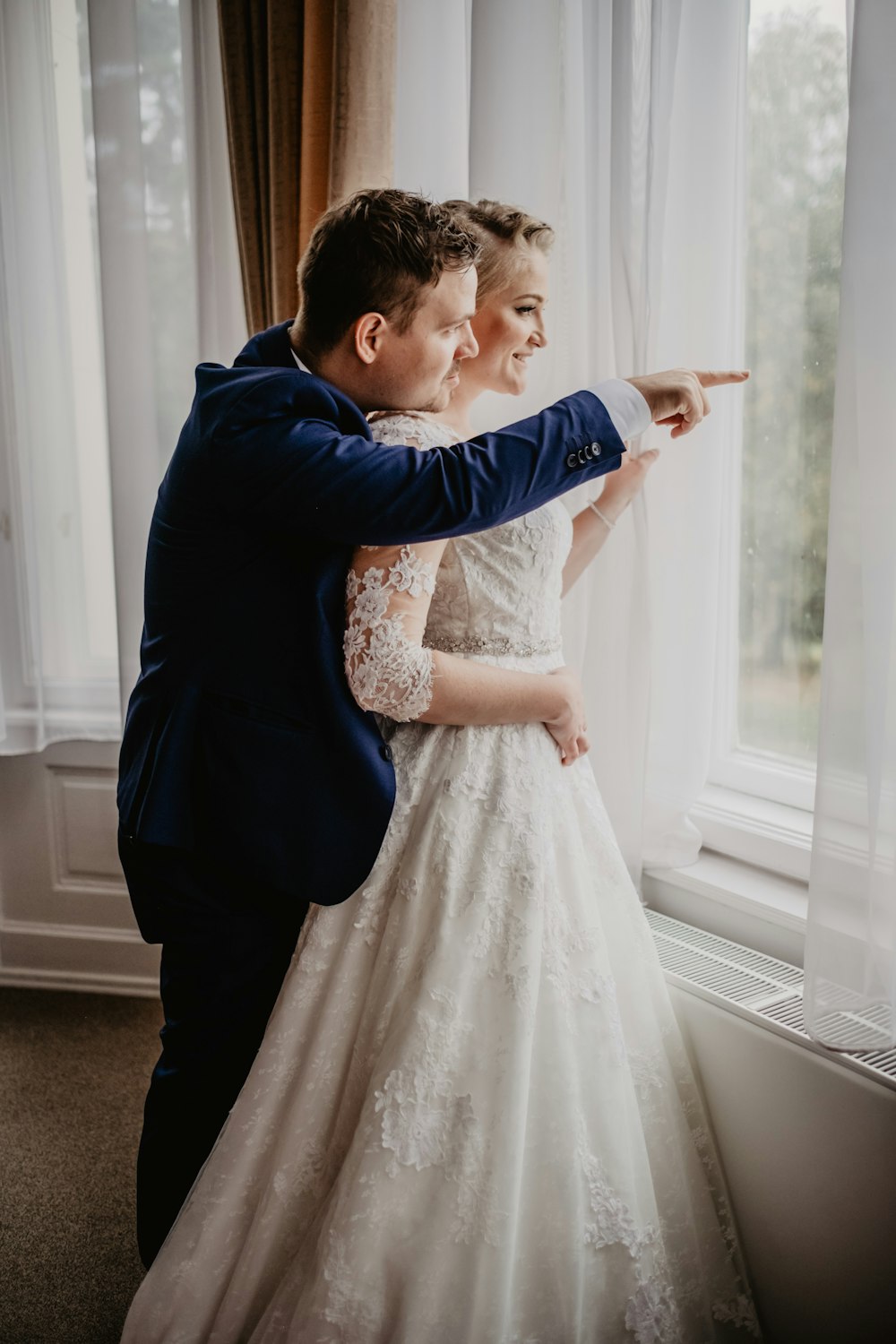 man in blue dress shirt holding girl in white dress