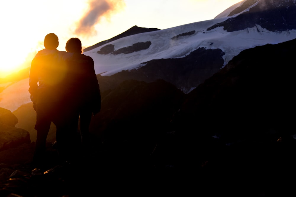 silhouette of person standing on mountain during daytime