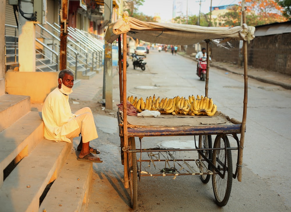 man in yellow polo shirt sitting on black metal cart