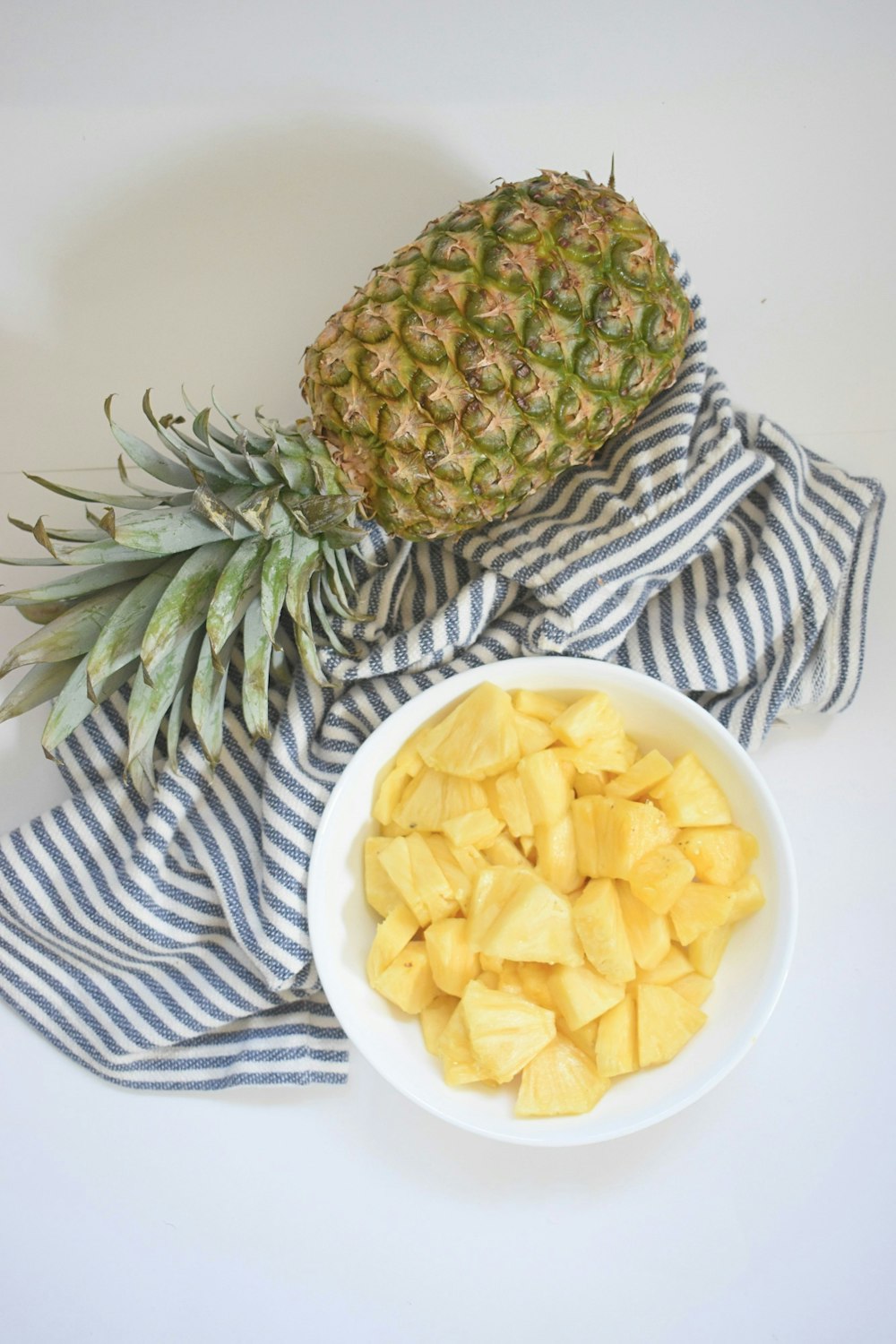 yellow and green pineapple fruit on white ceramic plate