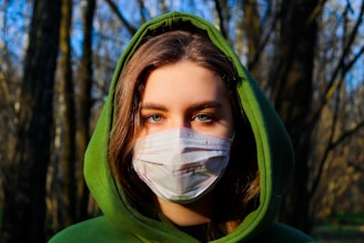 woman in green hoodie wearing white face mask