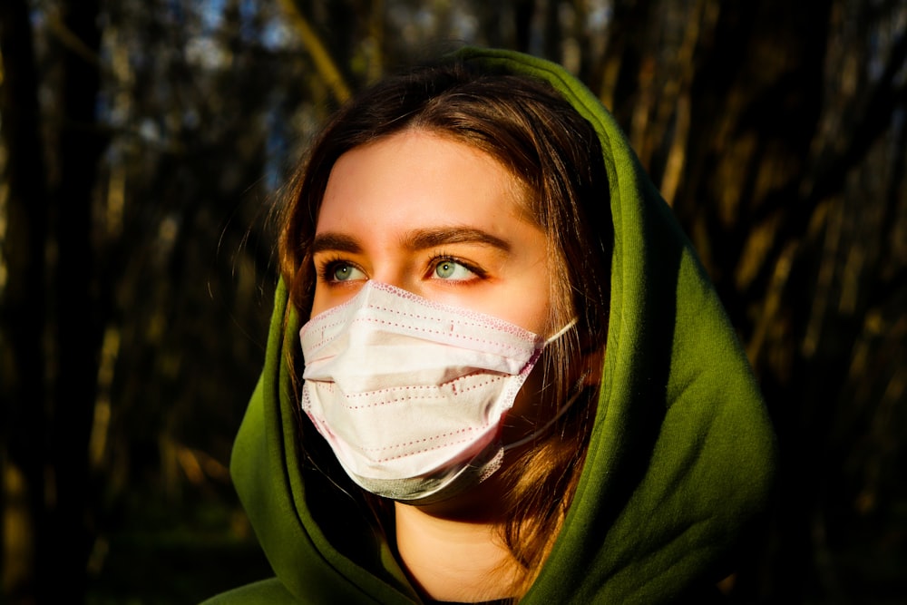 woman in green hoodie with white face mask