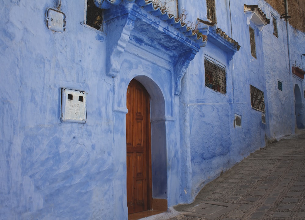 a blue building with a wooden door and window