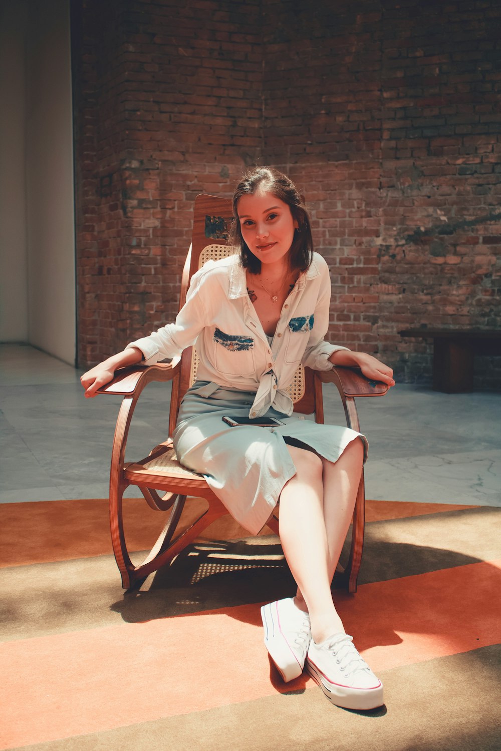 woman in white blazer sitting on brown wooden chair