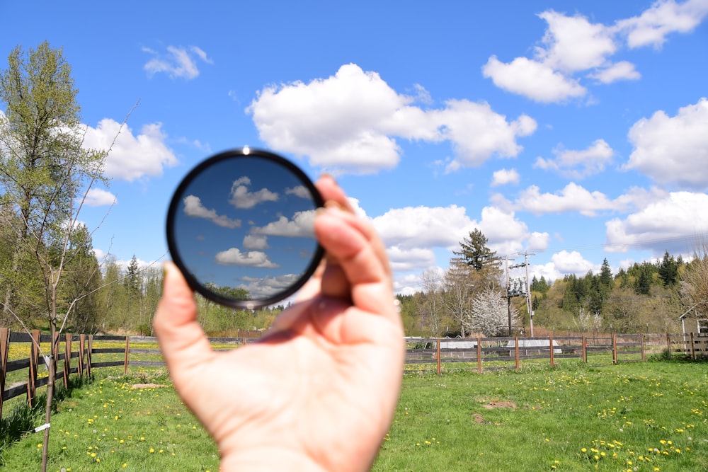 person holding round black frame