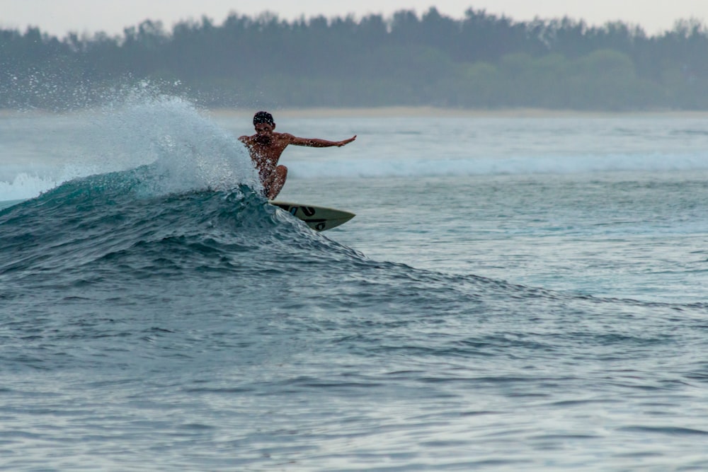 man surfing on sea during daytime