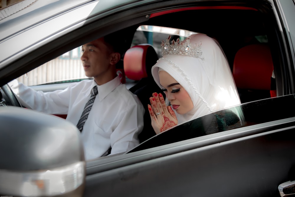 man in white suit jacket and woman in white wedding dress