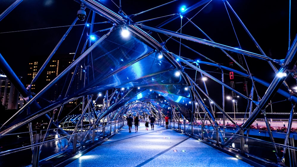 a walkway with people walking on it at night