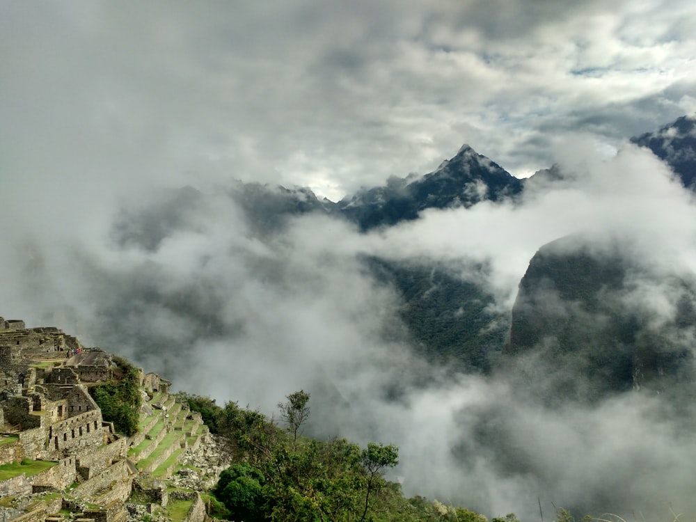 a view of a mountain range with clouds rolling over it