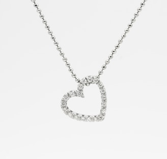 silver heart pendant necklace on white background
