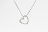 A delicate necklace with a shimmering diamond pendant against a soft background.