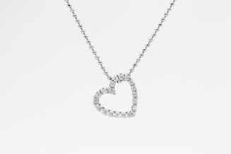 silver heart pendant necklace on white background