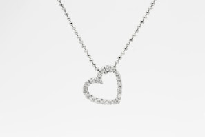 silver heart pendant necklace on white background