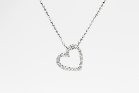 silver heart pendant necklace on white background