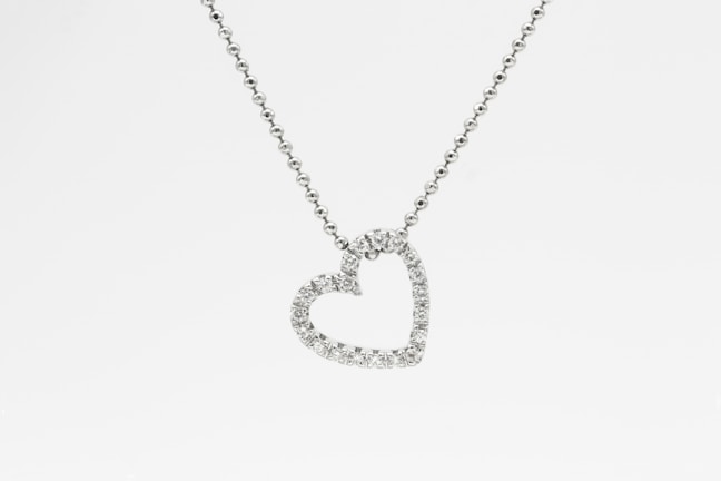 Diamond-studded pendant shining softly against a dark background, highlighting its craftsmanship.