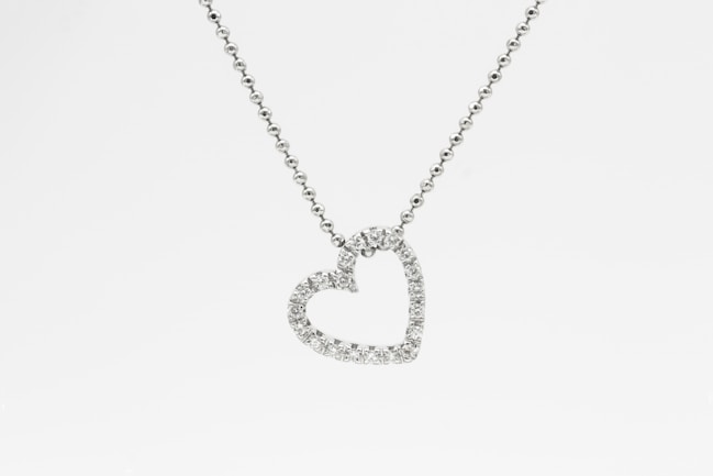 silver heart pendant necklace on white background