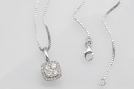 A delicate necklace with sparkling diamonds resting on black silk.