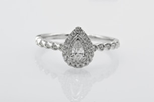 silver diamond studded ring on white surface